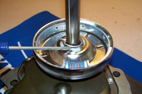 1994 Ford F-150 - A screwdriver is used on a chrome-plated washing machine component with visible wire connectors.