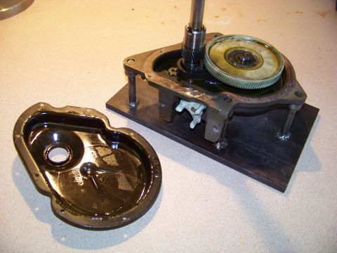 1994 Ford F-150 - A disassembled transmission component is shown on a workbench, with oil present in the housing.