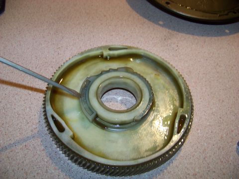 1994 Ford F-150 - A screwdriver is used to interact with a component of a transmission, possibly for repair or inspection.