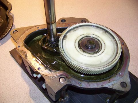 1994 Ford F-150 - Close-up view of internal transmission components, including gears and a shaft, within a metal housing filled with dark fluid.