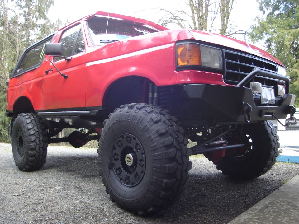 Red lifted Ford Bronco with big tires and aftermarket bumper