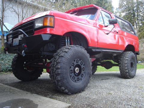 1989 Ford Bronco - This heavily modified Ford Bronco features an aggressive lift kit, oversized off-road tires, and a custom front bumper with a winch.