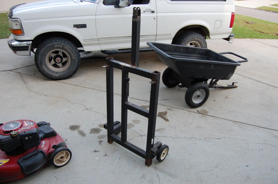 Homemade black steel dolly on a driveway with a white Ford Bronco behind it