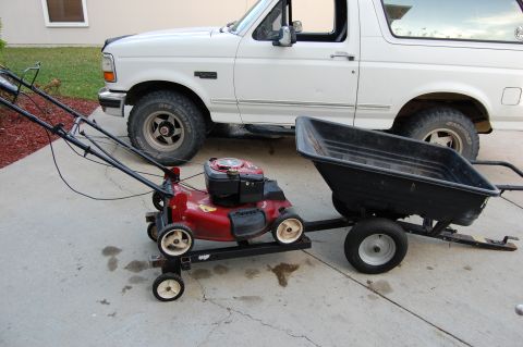 1994 Ford Bronco - A 1994 Ford Bronco is parked behind a lawnmower and trailer setup.