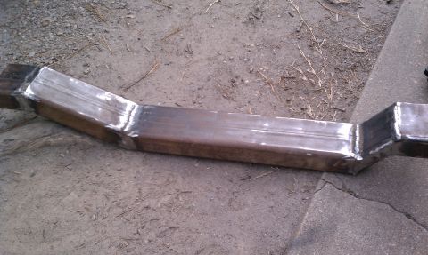 1990 Ford Bronco - A fabricated steel tube section, likely a custom part, lies on the ground.