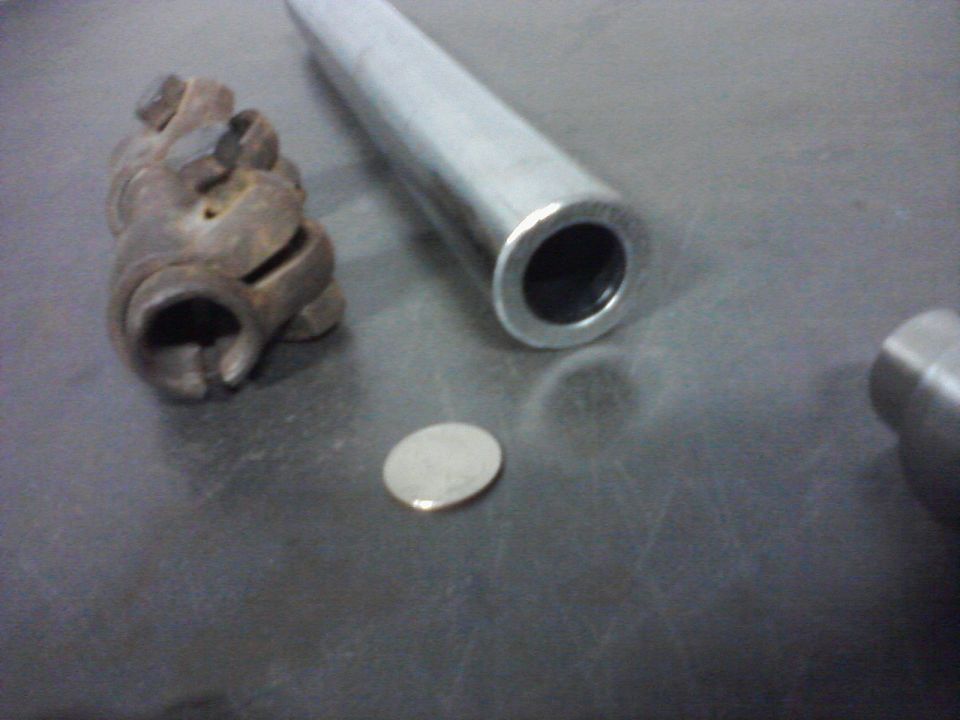Rusty U-joint and metal tube on a dark surface