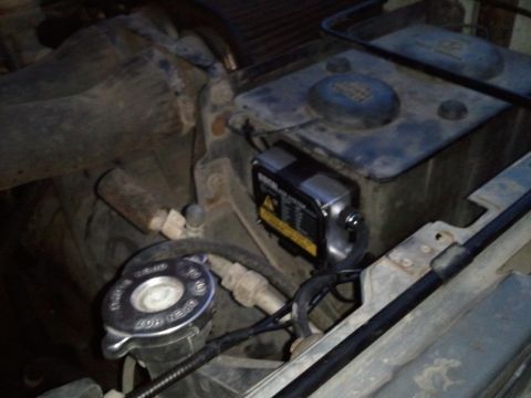 1989 Ford Bronco - Engine bay of a 1989 Ford Bronco, an aftermarket HID conversion ballast and radiator cap.