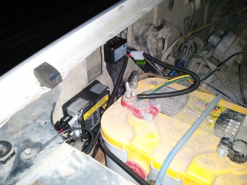 1989 Ford Bronco - Close-up of a vehicle's engine bay, a battery and electrical components.