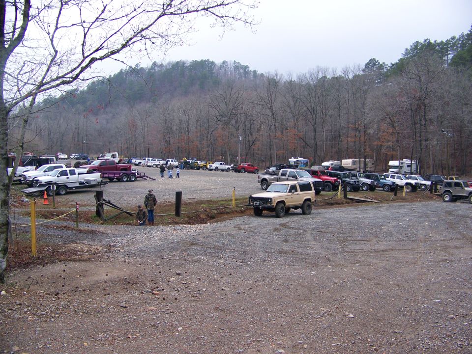 Parking lot with many trucks and SUVs, including a tan 1992 Jeep YJ in the foreground