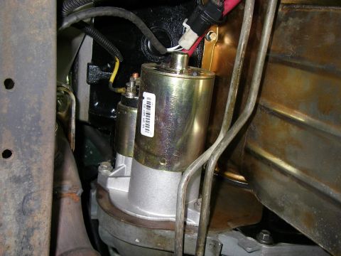 1990 Ford Bronco - Close-up view of a vehicle's starter motor, showing electrical connections and a part number label.