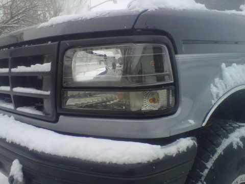 1994 Ford F-150 - A snow-covered Ford F-Series truck shows its front grille and headlight assembly.