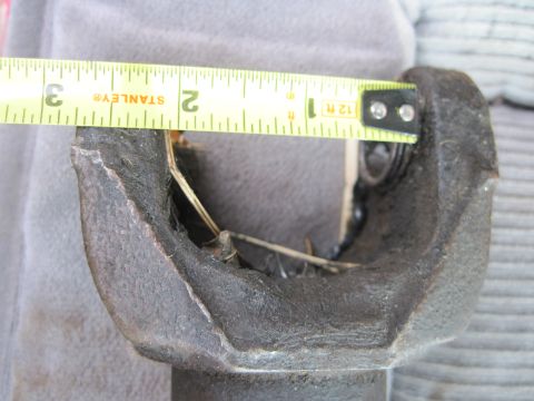 1978 Ford Bronco - Close-up of a damaged driveshaft U-joint being measured, indicating a potential mechanical issue.