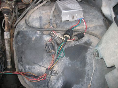1981 Ford Bronco - Close-up view of the wiring harness and electronic control module in a vehicle's engine compartment.