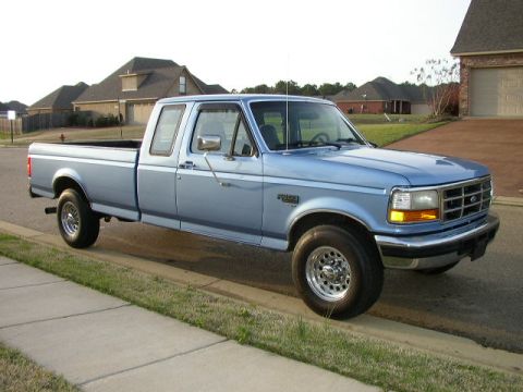 1995 Ford Bronco - This 1995 Ford F-150 pickup truck is parked on the side of a suburban street.