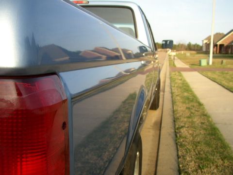 1995 Ford Bronco - Rear quarter panel and taillight of a 1995 Ford Bronco parked on a residential street.