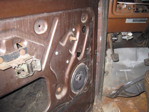 1979 Ford Bronco - View of the interior door panel, speaker, and floor pedals, showing the internal components of the vehicle.
