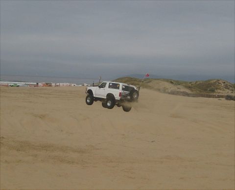 1996 Ford Bronco - A white Ford Bronco takes flight over a sand dune at Pismo Beach in March 2011.