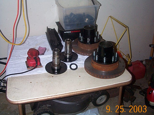 Brake rotors hubs and spindles on a workbench in a garage