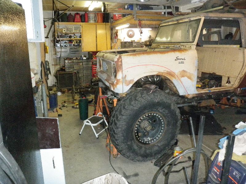 1961 International Scout 800 body on stands in a garage, undergoing modifications