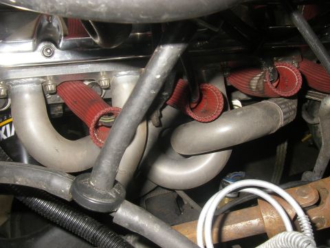 1990 Ford Bronco - Close-up view of engine exhaust manifold and associated hoses.