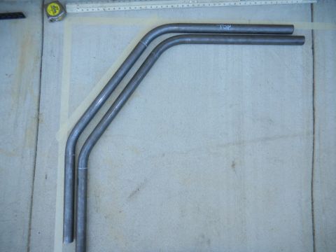 1997 Ford Ranger - Three bent metal tubes are arranged on a concrete surface, with markings indicating orientation.
