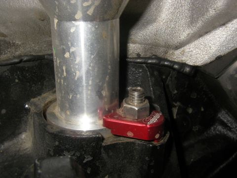 1990 Ford Bronco - Close-up of a red anodized CSR billet aluminum distributor hold-down clamp with a stainless bolt, securing a polished aluminum distributor…