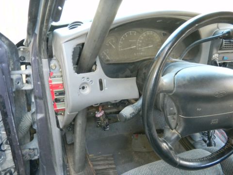 1997 Ford Ranger - The interior of a vehicle shows a steering wheel, dashboard gauges, and a prominent roll cage structure.