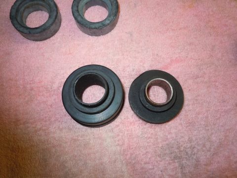 1970 Chevrolet Camaro - A collection of rubber bushings, some with metal inserts, are laid out on a pink fabric surface.