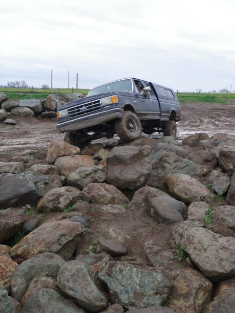 1991 Ford Bronco - Ford F-Series truck is shown attempting to traverse a large rock formation.