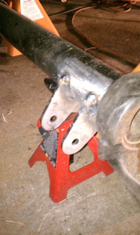 1990 Ford Bronco - This image shows a close-up of a vehicle's axle housing, which has been welded and is resting on jack stands.