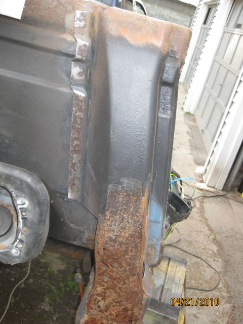 1983 Ford Bronco - A close-up view of a heavily rusted and painted metal component, likely from a vehicle's undercarriage.
