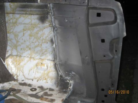 1983 Ford Bronco - Close-up view of the interior of a vehicle body panel, showing signs of rust and staining.