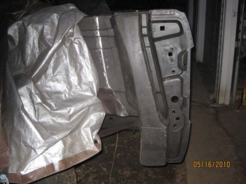 1983 Ford Bronco - A car door frame, partially obscured by a silver tarp, shows its internal structure and mounting points.