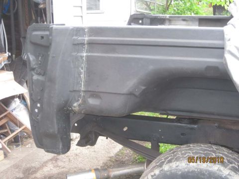 1983 Ford Bronco - Close-up of the rear corner of a truck bed, highlighting repair welds on the support structure.
