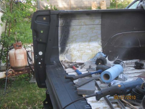 1983 Ford Bronco - Tools and supplies are laid out in the bed of a truck, with a propane tank in the background.