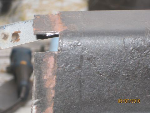1983 Ford Bronco - Metal bracket with a hole, likely a vehicle part, with a date stamp and website in the corner.