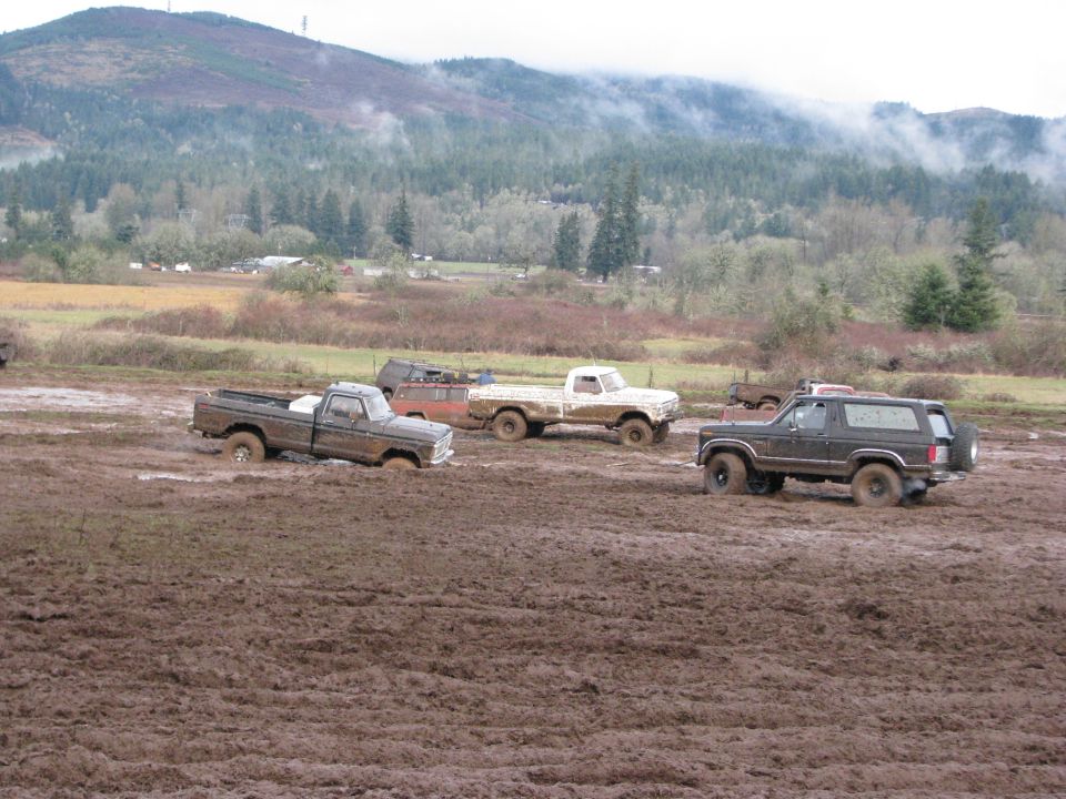 Four-wheel drive vehicles stuck in mud, including a 1978 Ford Bronco