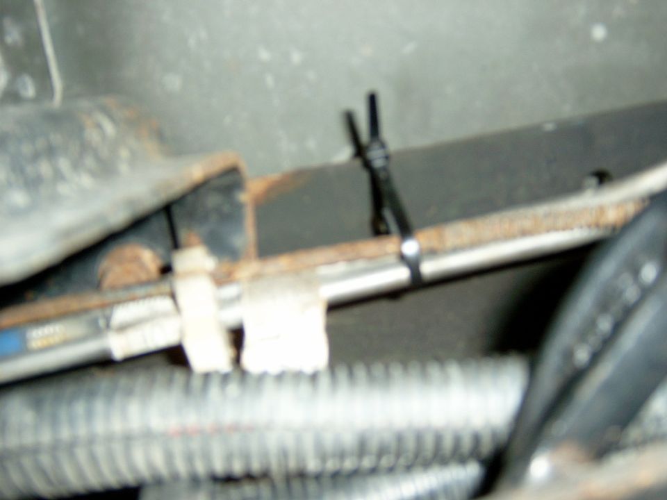 The driver’s side radius arm bracket was not as easy as the passenger side, because the fuel lines, parking brake wire, and 2 wire looms of wires were in the way.  I had to unbolt the fuel line holder from the frame and zip tie it up out of the way of my drill bit