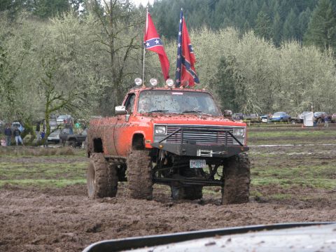 1978 Ford Bronco - Mud bogging event features a heavily modified pickup truck flying Confederate flags.