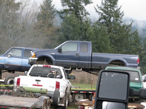 1978 Ford Bronco - A blue Ford F-250 pickup truck is seen on a trailer, with other vehicles also present in the scene.