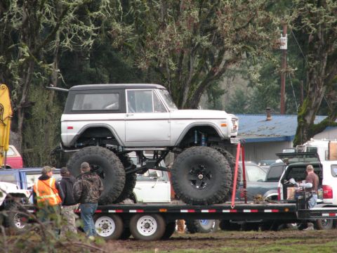 1978 Ford Bronco - Customized 1978 Ford Bronco with extreme lift and tires is loaded onto a trailer.