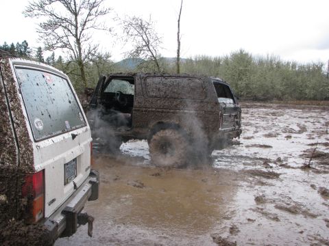 1978 Ford Bronco - Two off-road vehicles are stuck deep in the mud during an off-road excursion.