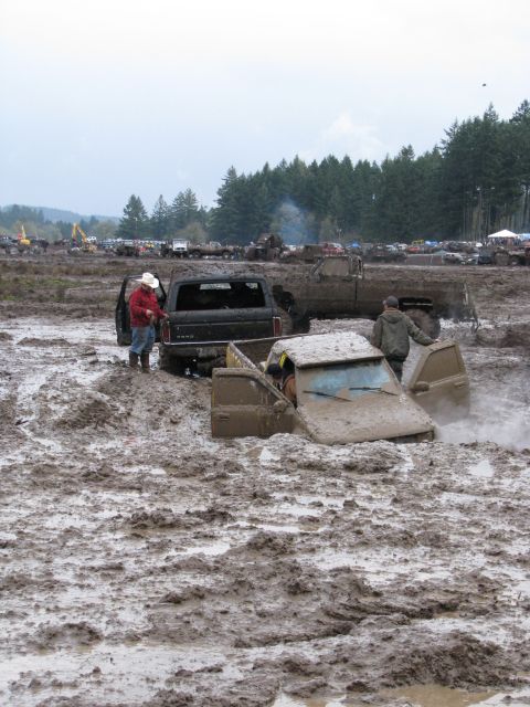 1978 Ford Bronco - Several vehicles are stuck deep in the mud during an off-road event.