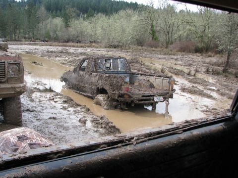 1978 Ford Bronco - Pickup truck deeply stuck in mud, with another vehicle nearby in a muddy off-road scene.