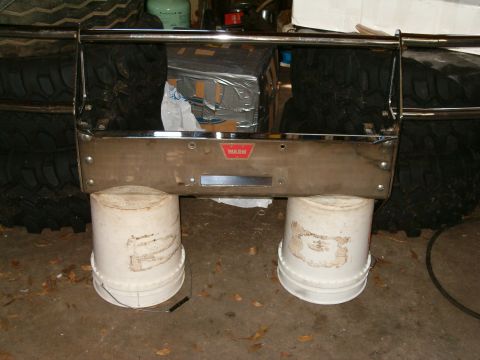 1991 Ford Bronco - A WARN winch bumper is shown, supported by buckets, with tires visible behind it.