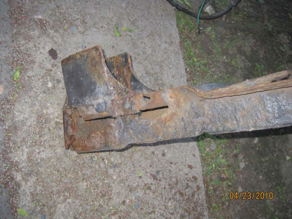 rusted metal frame piece on concrete, date stamp in corner