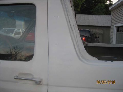 1983 Ford Bronco - Close side view of the B-pillar area on a topless white Bronco, showing the primered and blended panel joint behind the door with two small…