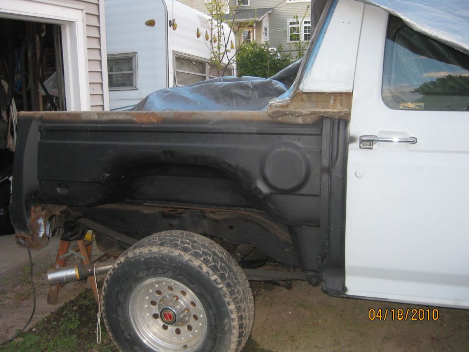 White Bronco with outer rear quarter removed, exposing black inner tub and open wheel arch