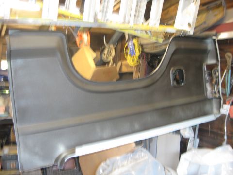 1983 Ford Bronco - Slightly blurred shot of a gray molded plastic interior trim panel, a rear quarter or door panel with a large armrest cutout, a recessed sw…