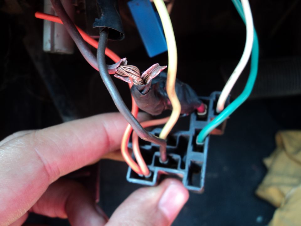 Close-up of a damaged wiring harness with exposed copper wires
